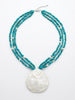 A three-strand turquoise with white pearl accent and a Reversible Turquoise and carved Mother of Pearl Pendant